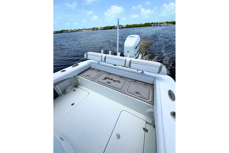 Slide: The Image of 2018 Yellowfin 26 Hybrid boat on water, showcasing spacious deck and powerful outboard motor. - 20