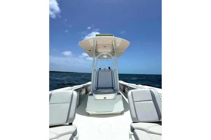 Slide: The Image of 2018 Yellowfin 26 Hybrid boat on open water under clear blue sky. - 10