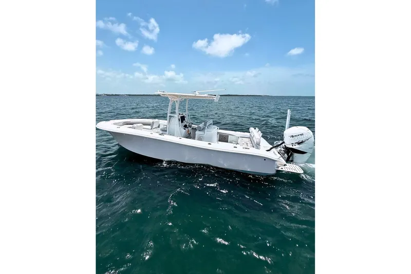 Slide: The Image of 2018 Yellowfin 26 Hybrid boat on open water under clear blue sky. - 6