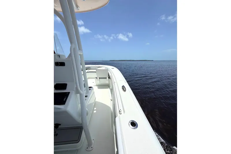 Slide: The Image of 2018 Yellowfin 26 Hybrid boat cruising on open water under clear blue sky. - 21