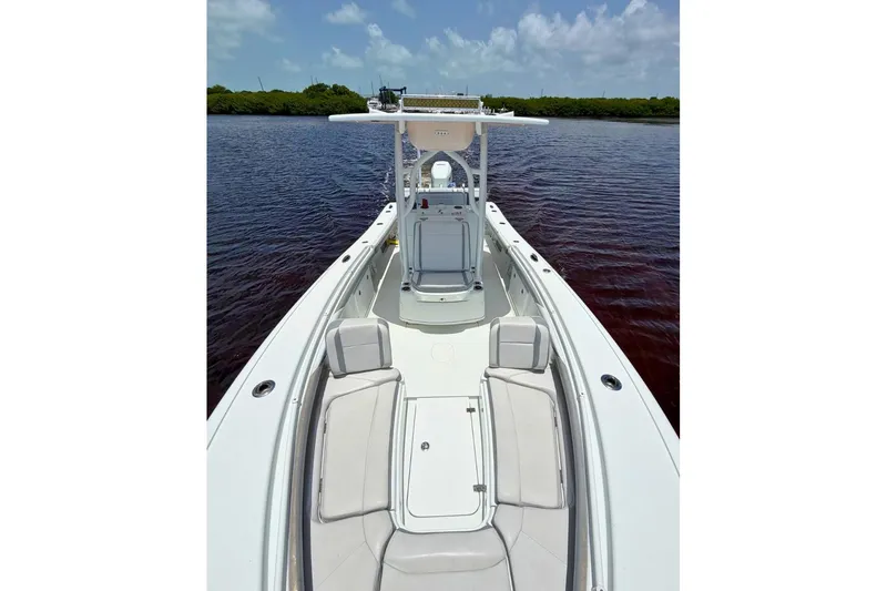 Slide: The Image of 2018 Yellowfin 26 Hybrid boat on calm water, showcasing spacious deck and seating. - 23