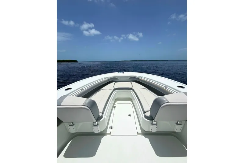 Slide: The Image of 2018 Yellowfin 26 Hybrid boat interior with seating, overlooking calm ocean waters. - 22