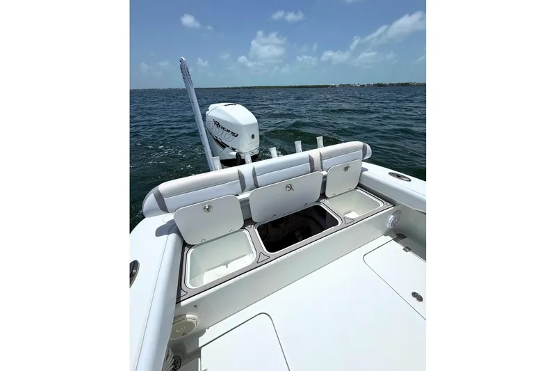 Slide: The Image of 2018 Yellowfin 26 Hybrid boat with open storage compartments on a sunny day at sea. - 11
