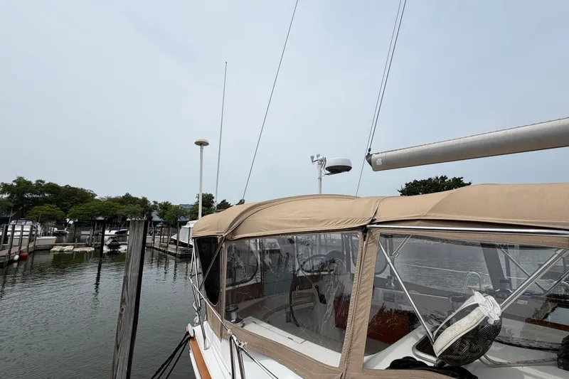 Slide: The Image of 2007 Beneteau 423 sailboat docked at marina, featuring tan canopy and clear windows. - 11