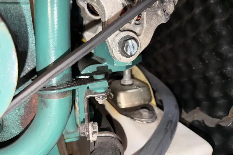 Slide: The Image of Close-up of a 2007 Beneteau 423 engine component with belt and bolt details. - 48