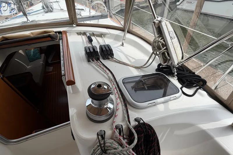 Slide: The Image of 2007 Beneteau 423 yacht deck with winch, ropes, and hatch in marina setting. - 16