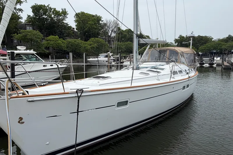 Slide: The Image of 2007 Beneteau 423 sailboat docked in a marina, surrounded by lush greenery. - 1