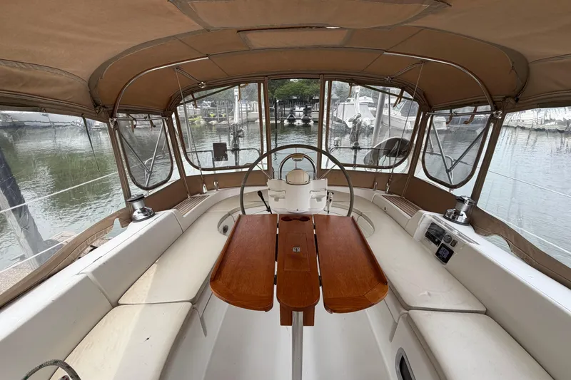 Slide: The Image of 2007 Beneteau 423 sailboat cockpit with wooden table and steering wheel, docked at marina. - 19