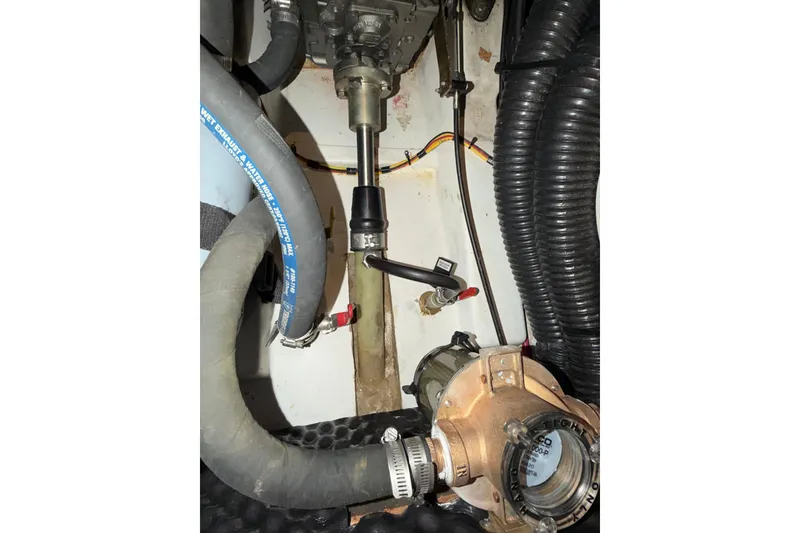 Slide: The Image of Engine compartment of a 2007 Beneteau 423 sailboat, showing hoses and mechanical components. - 56