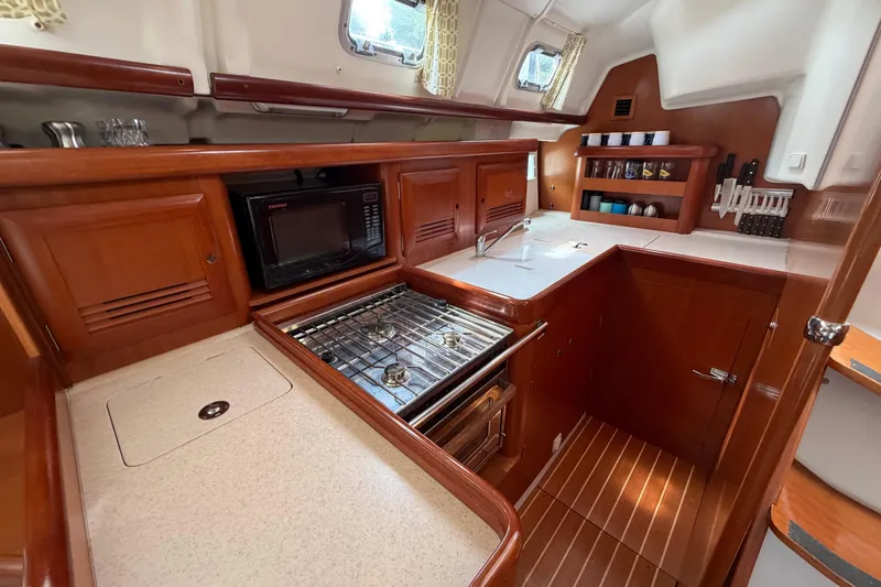 Slide: The Image of Luxurious 2007 Beneteau 423 yacht kitchen with wood cabinetry and modern appliances. - 26