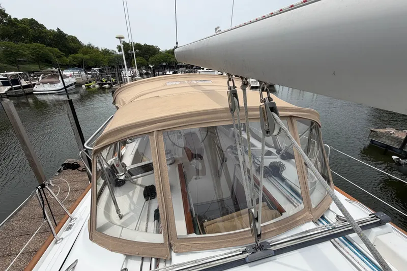Slide: The Image of 2007 Beneteau 423 sailboat docked, featuring beige canopy and marina background. - 10