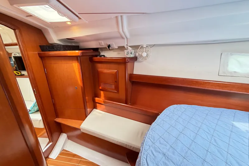 Slide: The Image of Interior cabin of 2007 Beneteau 423 yacht with wooden cabinetry and blue bedding. - 44