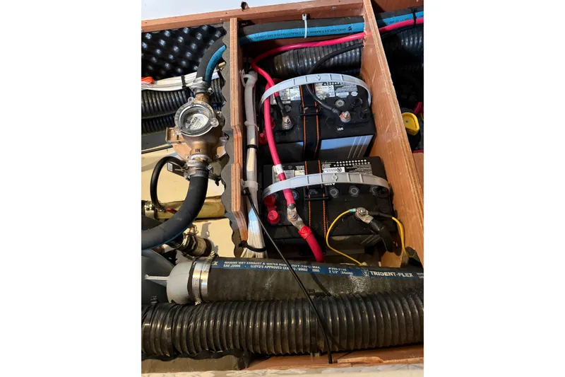 Slide: The Image of Engine compartment of a 2007 Beneteau 423 sailboat, featuring batteries and hoses. - 51