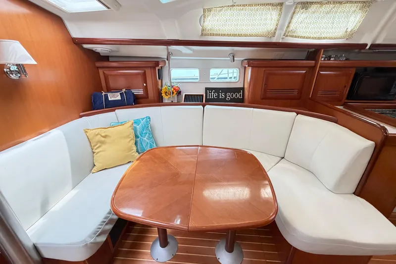 Slide: The Image of Cozy interior of 2007 Beneteau 423 sailboat with cushioned seating and wooden table. - 35
