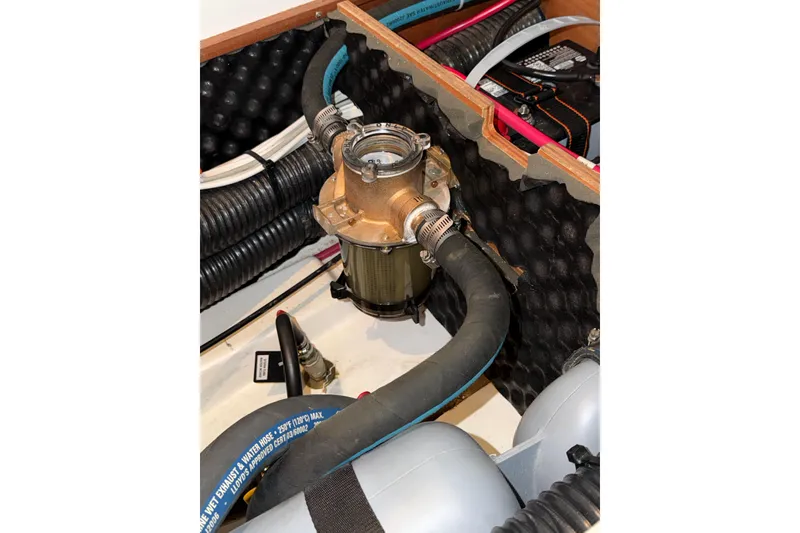 Slide: The Image of Engine compartment of a 2007 Beneteau 423 sailboat, featuring hoses and mechanical components. - 57