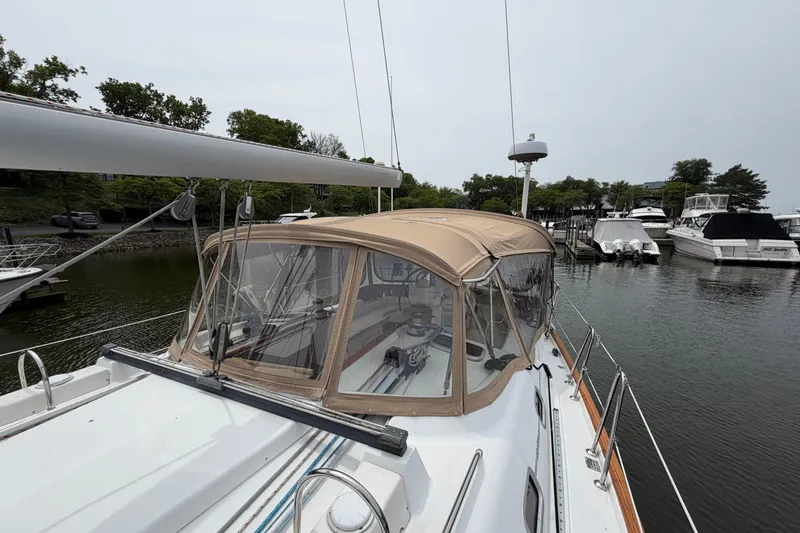 Slide: The Image of 2007 Beneteau 423 sailboat docked in a marina, featuring a tan canopy and sleek design. - 8