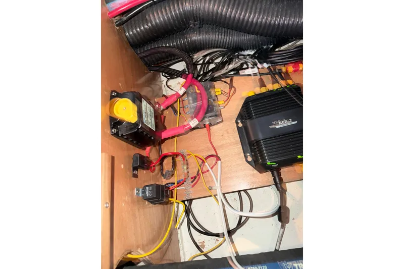 Slide: The Image of Electrical components inside a 2007 Beneteau 423 yacht, featuring wiring and a NEP-2 device. - 54