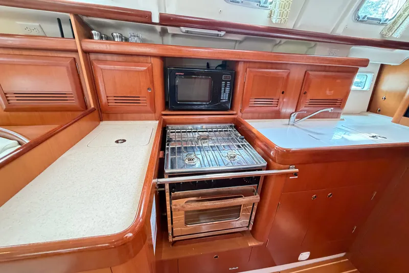 Slide: The Image of Luxurious 2007 Beneteau 423 yacht kitchen with stove, microwave, and sink. - 27