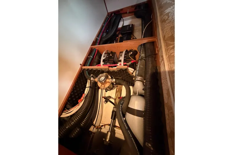 Slide: The Image of Engine compartment of a 2007 Beneteau 423 sailboat, showcasing hoses and mechanical components. - 52