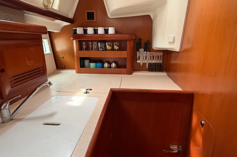 Slide: The Image of Interior of 2007 Beneteau 423 yacht kitchen with wooden cabinetry and countertop. - 28