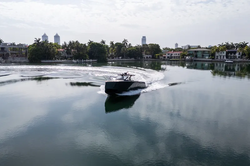 Slide: The Image of 2020 Pardo Yachts 50 cruising on a calm, scenic waterway with city skyline backdrop. - 24