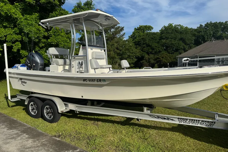 Slide: The Image of 2021 KenCraft Bayrider boat on trailer, parked on grass, with trees and house in background. - 18
