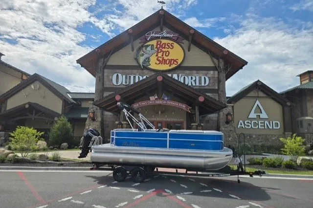The Image of 2026 Sun Tracker Party Barge 20 DLX pontoon boat outside Bass Pro Shops. - 0