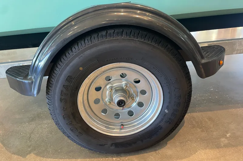 Slide: The Image of Trailer wheel of a 2026 Mako Pro Skiff 15 CC boat. - 6