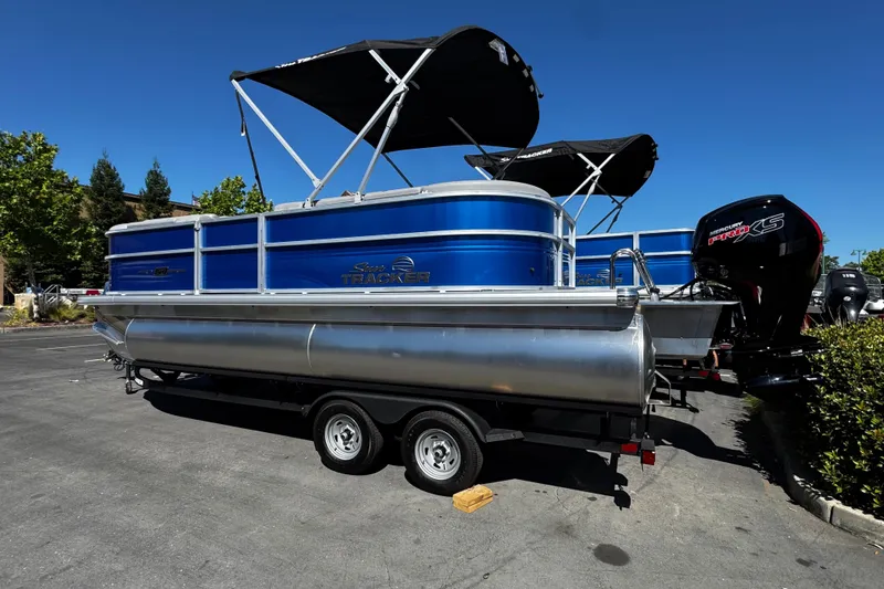 Slide: The Image of 2026 Sun Tracker Party Barge 20 DLX pontoon boat on trailer, parked outdoors. - 9