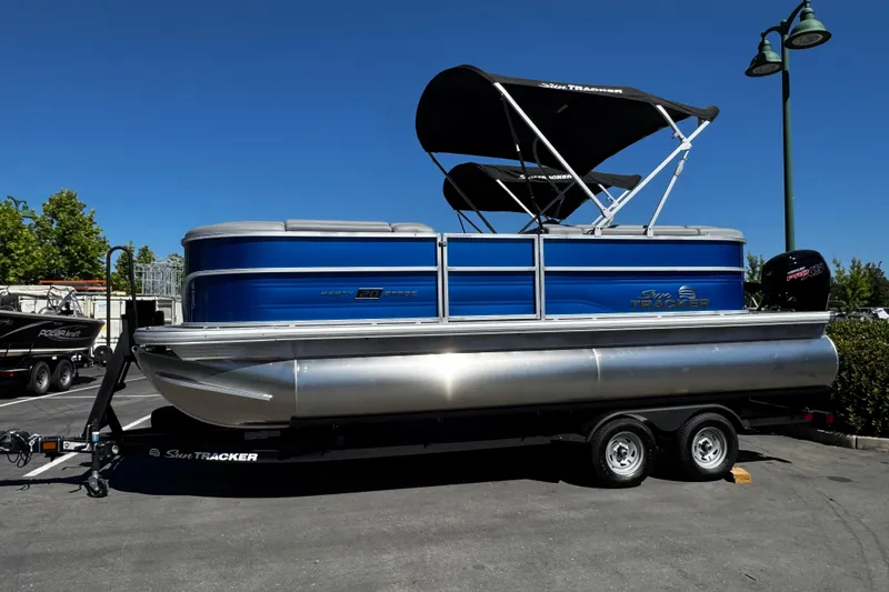 Slide: The Image of 2026 Sun Tracker Party Barge 20 DLX pontoon boat on trailer, parked outdoors. - 3
