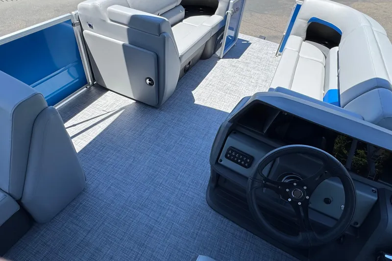 Slide: The Image of 2026 Sun Tracker Party Barge 20 DLX interior with gray seating and steering console. - 21