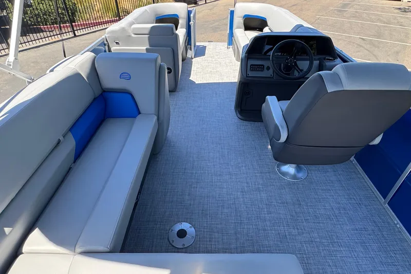 Slide: The Image of 2026 Sun Tracker Party Barge 20 DLX interior with gray seating and steering console. - 20