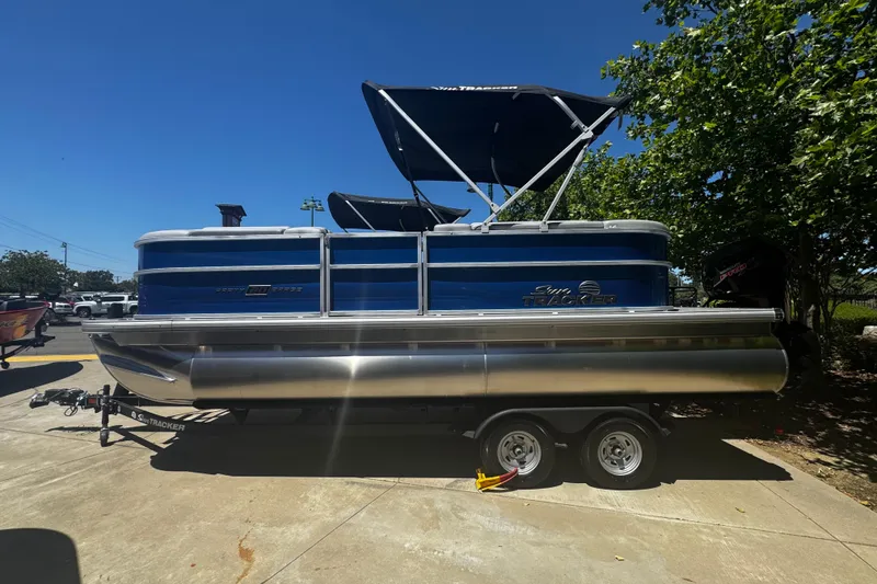 The Image of 2026 Sun Tracker Party Barge 20 DLX pontoon boat on trailer, parked outdoors. - 0