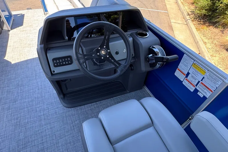 Slide: The Image of 2026 Sun Tracker Party Barge 20 DLX helm with steering wheel and controls. - 17