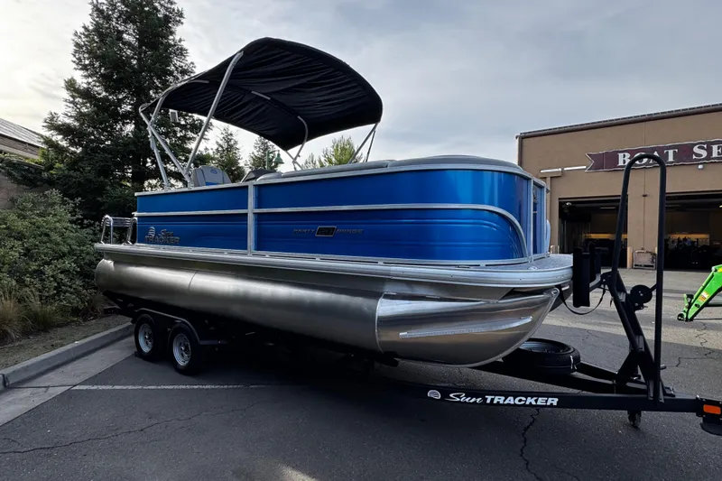 Slide: The Image of 2026 Sun Tracker Party Barge 20 DLX pontoon boat on trailer, parked outdoors. - 6
