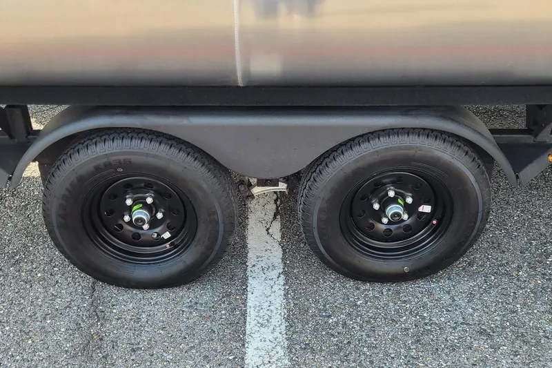 Slide: The Image of Trailer wheels of 2026 Sun Tracker Fishin' Barge 22 XP3 on asphalt. - 12
