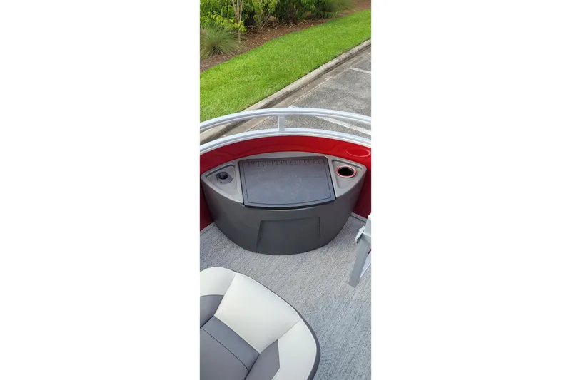 Slide: The Image of 2026 Sun Tracker Fishin' Barge 22 XP3 boat interior with seating and storage compartment. - 8
