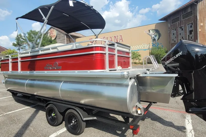 Slide: The Image of 2026 Sun Tracker Fishin' Barge 22 XP3 pontoon boat with Mercury engine, parked outdoors. - 2
