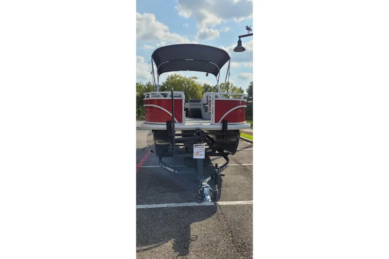 Slide: The Image of 2026 Sun Tracker Fishin' Barge 22 XP3 pontoon boat on trailer, parked outdoors. - 11