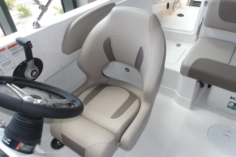 Slide: The Image of 2026 Tahoe 2150 boat interior with steering wheel and beige seating. - 19