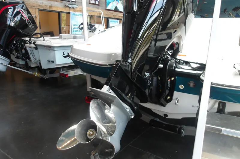 Slide: The Image of 2026 Tahoe 2150 boat with powerful outboard motor displayed indoors. - 10