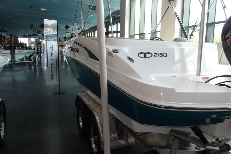 Slide: The Image of 2026 Tahoe 2150 boat displayed indoors on a trailer. - 7