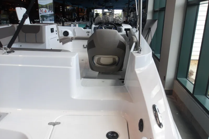 Slide: The Image of 2026 Tahoe 2150 boat interior with seating and steering wheel in showroom. - 13