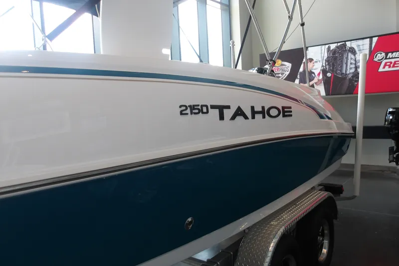Slide: The Image of 2026 Tahoe 2150 boat displayed indoors on a trailer. - 6