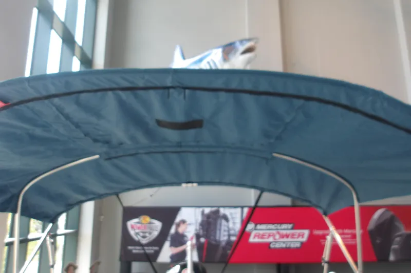Slide: The Image of Blue canopy of a 2026 Tahoe 2150 boat with shark decoration above. - 25