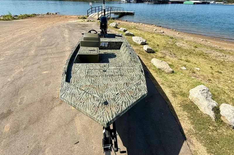 Slide: The Image of 2026 Tracker Grizzly 1648 SC boat on a lakeside ramp, ready for launch. - 15