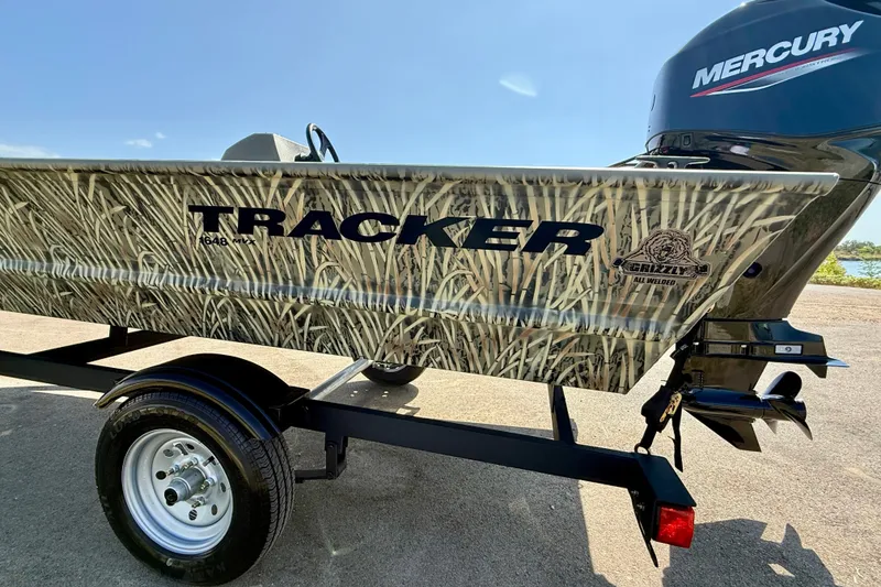 Slide: The Image of 2026 Tracker Grizzly 1648 SC boat with camo design and Mercury engine. - 14