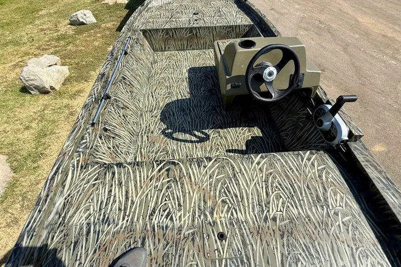 Slide: The Image of 2026 Tracker Grizzly 1648 SC boat with camouflage interior design and steering console. - 17