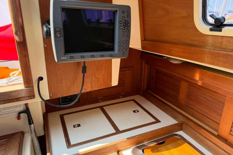 Slide: The Image of Interior of 1991 Tartan 28 Piper sailboat with navigation equipment and wooden cabinetry. - 13