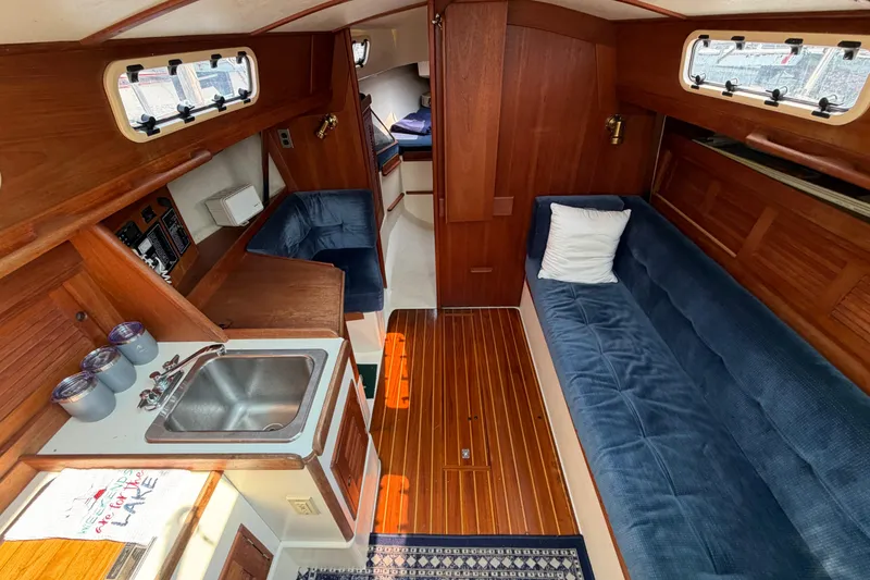 Slide: The Image of Interior of 1991 Tartan 28 Piper sailboat with wood finish and blue seating. - 22